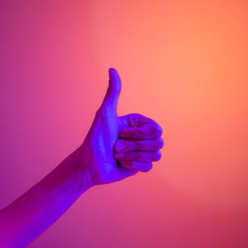 persons hand doing thumbs up