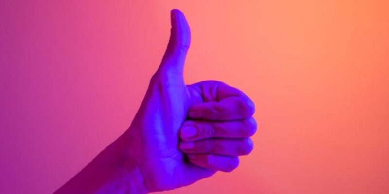 persons hand doing thumbs up